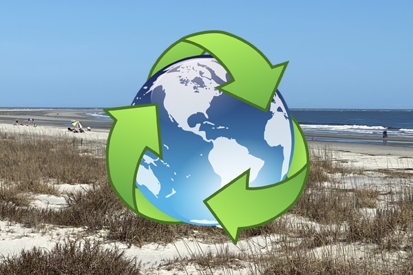 A globe with green recycling arrows overlays a sandy beach and ocean on a sunny Lowcountry, South Carolina vacation.