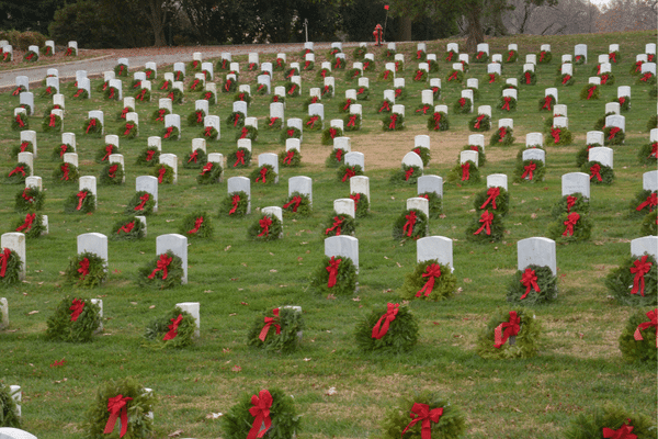 Rows of headstones, adorned with wreaths and bows, evoke memories like a family vacation during the holiday season.