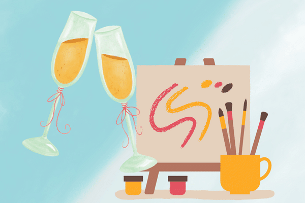 Two champagne glasses, abstract art on an easel, and art supplies evoke a Fripp Island vacation rental vibe.