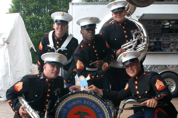 Five U.S. Marines in dress uniforms pose with instruments and a bass drum, perfect for a Fripp Island family vacation.