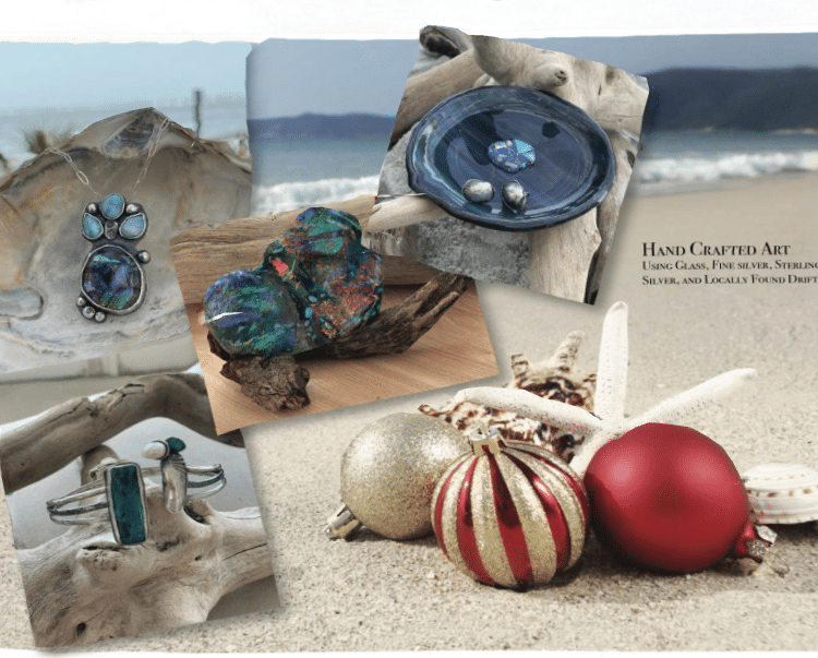 Handcrafted jewelry and ornaments displayed on driftwood with a beach backdrop.