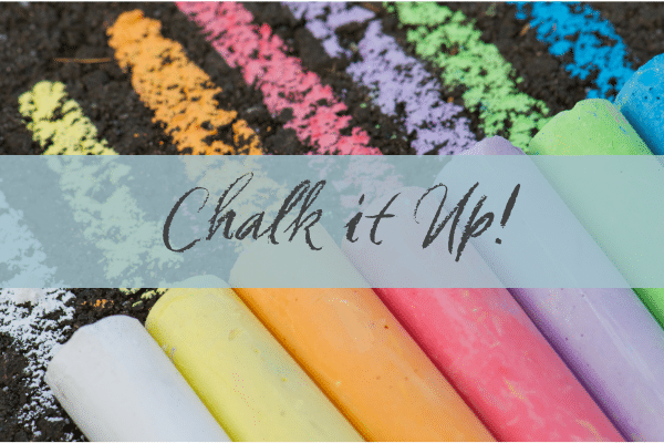 Colorful chalk sticks and drawn lines on ground, with text Chalk it Up over a transparent banner.