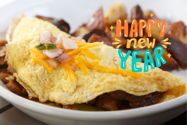A cheesy omelet with toppings on a plate, beside bright Happy New Year text—perfect for a Lowcountry family vacation.