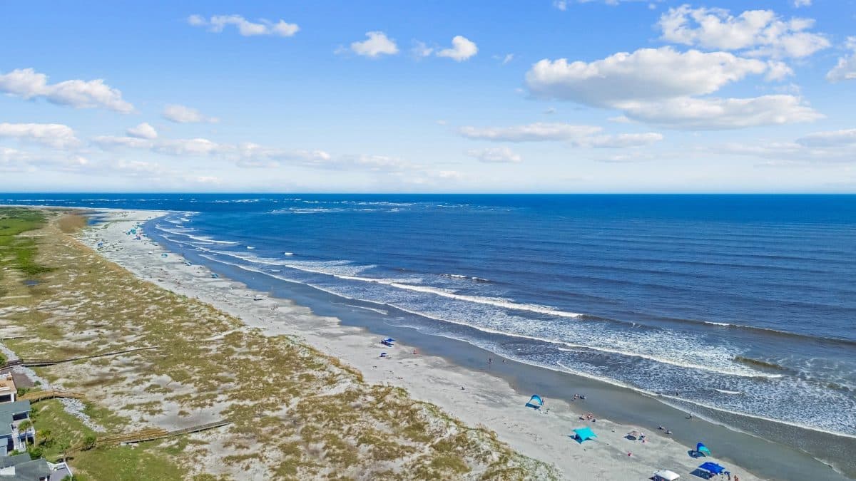 Aerial view of a sandy beach with waves—perfect for a family vacation or relaxing Fripp Island vacation.