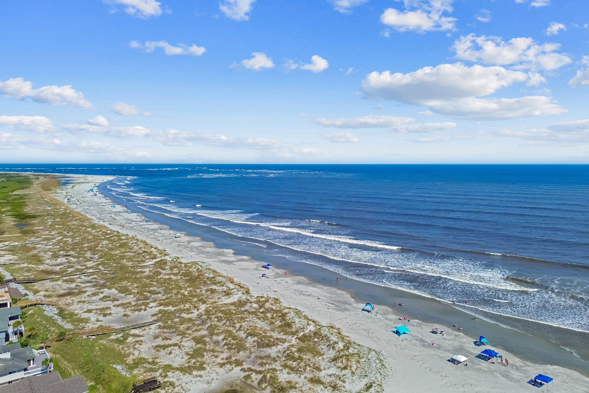 Aerial view of a sandy beach with waves—perfect for a family vacation or relaxing Fripp Island vacation.
