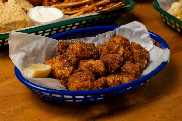 Fried fish bites in a blue basket with a lemon wedge, served at Marker 244 in the South Carolina Lowcountry