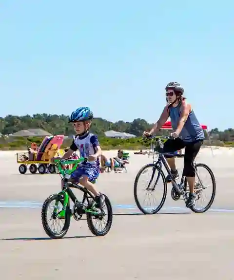 Mother and son riding bikes on beach